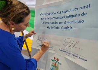 FOTOGRAFÍA, FIRMA DE LA MINISTRA HELGA RIVAS PARA EL INICIO DE ESTUDIOS, DISEÑOS PARA LA OBRA DE UN PARQUE RECREODEPORTIVO EN EL BARRIO ZONA INDÍGENA